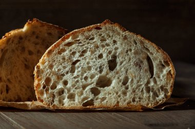 Ekmek, kırsal ahşap arka planda dilimlenmiş geleneksel ekşi ekmek. Geleneksel mayalanmış ekmek pişirme yöntemleri kavramı. Sağlıklı yemek..