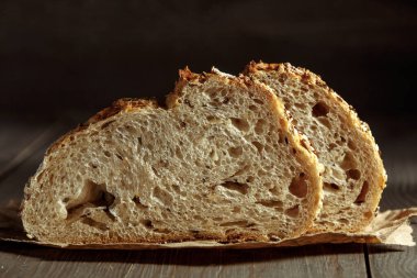 Ekmek, kırsal ahşap arka planda dilimlenmiş geleneksel ekşi ekmek. Geleneksel mayalanmış ekmek pişirme yöntemleri kavramı. Sağlıklı yemek..