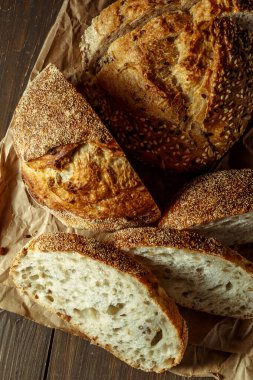 Ekmek, kırsal ahşap arka planda dilimlenmiş geleneksel ekşi ekmek. Geleneksel mayalanmış ekmek pişirme yöntemleri kavramı. Sağlıklı yemek..