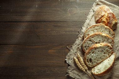 Ekmek, kırsal ahşap arka planda dilimlenmiş geleneksel ekşi ekmek. Geleneksel mayalanmış ekmek pişirme yöntemleri kavramı. Sağlıklı yemek..