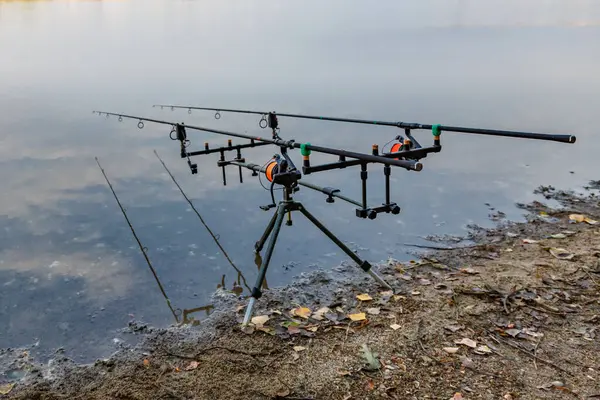 Carpfishing session at the Lake.Carp fishing rods standing on special tripods.Scenic landscape overlooking lake at Dawn.Fishing adventures, carp fishing.