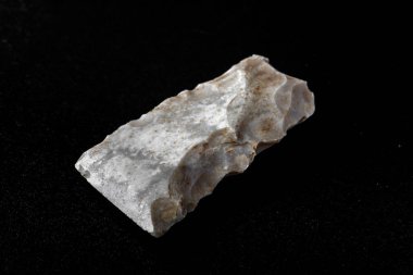 Tarih öncesi taş balta, siyah arka planda izole edilmiş. İlkel adam. İskitli dönem. Eski nesneler üzerine çalışma