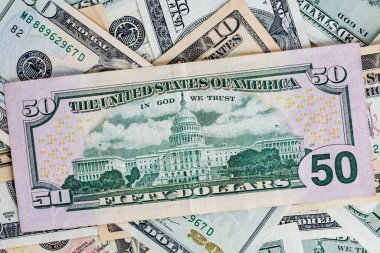 Money American yüz dolarlık banknotlar. Dolarlar arka planda. Çeşitli Amerikan banknotları. Masaya saçılmış Amerikan paraları.