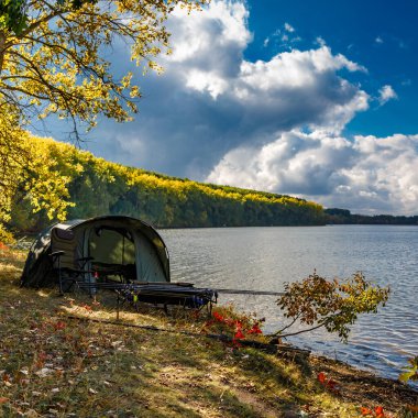 Gölde balık avı. Şafak vakti göle bakan sazan balığı avı manzarası. Balık maceraları, sazan balıkçılığı..