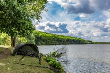 Gölde balık avı. Şafak vakti göle bakan sazan balığı avı manzarası. Balık maceraları, sazan balıkçılığı..