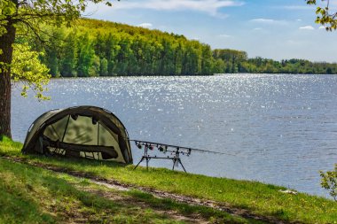 Gölde balık avı. Sazan balıkçılığı manzarası göl manzarası ve bulutlu mavi gökyüzü. Balıkçılık maceraları, sazan balığı avcılığı..