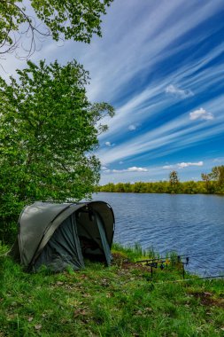 Gölde balık avı. Sazan balıkçılığı manzarası göl manzarası ve bulutlu mavi gökyüzü. Balıkçılık maceraları, sazan balığı avcılığı..