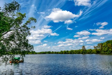 Gölde balık avı. Sazan balıkçılığı manzarası göl manzarası ve bulutlu mavi gökyüzü. Balıkçılık maceraları, sazan balığı avcılığı..