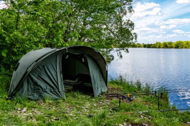 Gölde balık avı. Sazan balıkçılığı manzarası göl manzarası ve bulutlu mavi gökyüzü. Balıkçılık maceraları, sazan balığı avcılığı..