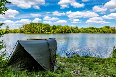 Gölde balık avı. Sazan balıkçılığı manzarası göl manzarası ve bulutlu mavi gökyüzü. Balıkçılık maceraları, sazan balığı avcılığı..