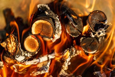 Parlak ahşap odunlar ve sarı ateş alevleri. Yanan ateş odunlarının dokusu. Açık ateş..