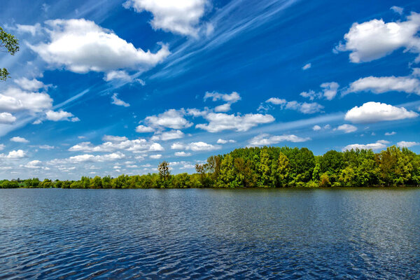 Carpfishing session at the Lake.Carp Angling scenic landscape overlooking lake at and blue sky with clouds.Fishing adventures, carp fishing.