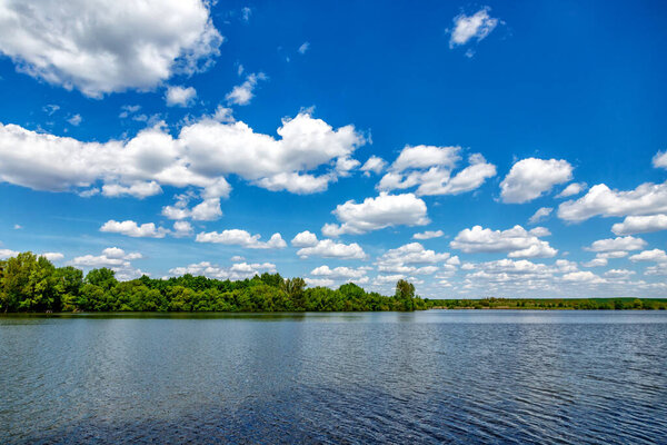 Carpfishing session at the Lake.Carp Angling scenic landscape overlooking lake at and blue sky with clouds.Fishing adventures, carp fishing.