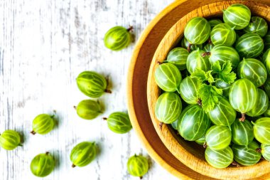 Yeşil Organik Böğürtlenler. Ahşap bir kasede yeşil Bektaşi üzümü. Ahşap masada Bektaşi üzümü. Hasat konsepti. Vejetaryen yemeği..