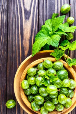 Yeşil Organik Böğürtlenler. Ahşap bir kasede yeşil Bektaşi üzümü. Ahşap masada Bektaşi üzümü. Hasat konsepti. Vejetaryen yemeği..