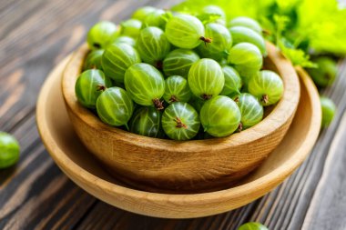 Yeşil Organik Böğürtlenler. Ahşap bir kasede yeşil Bektaşi üzümü. Ahşap masada Bektaşi üzümü. Hasat konsepti. Vejetaryen yemeği..