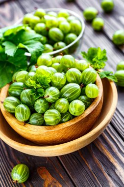 Yeşil Organik Böğürtlenler. Ahşap bir kasede yeşil Bektaşi üzümü. Ahşap masada Bektaşi üzümü. Hasat konsepti. Vejetaryen yemeği..