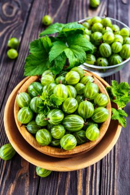 Yeşil Organik Böğürtlenler. Ahşap bir kasede yeşil Bektaşi üzümü. Ahşap masada Bektaşi üzümü. Hasat konsepti. Vejetaryen yemeği..
