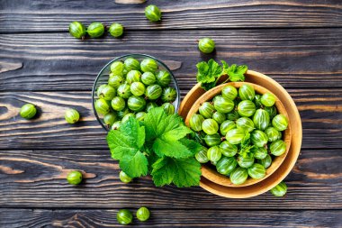 Yeşil Organik Böğürtlenler. Ahşap bir kasede yeşil Bektaşi üzümü. Ahşap masada Bektaşi üzümü. Hasat konsepti. Vejetaryen yemeği..