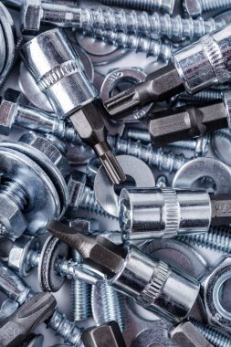 Çeşitli metal aletlerle kompozisyon. Soketler, aletler, dişliler ve ısırıklar. Vidalar ve çiviler. Endüstriyel arka plan. Çeşitli vidaları yakın plan. Arkaplan için kullan, 