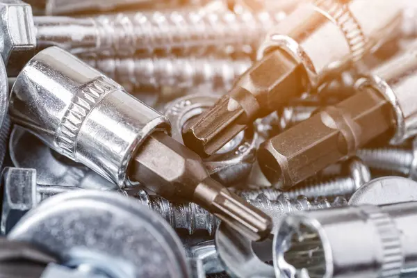 Çeşitli metal aletlerle kompozisyon. Soketler, aletler, dişliler ve ısırıklar. Vidalar ve çiviler. Endüstriyel arka plan. Çeşitli vidaları yakın plan. Arkaplan için kullan, 