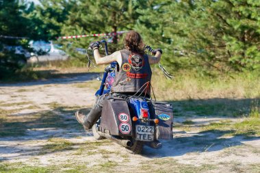 Ukrayna, Kyiv - 9 Temmuz 2011: Sakallı, siyah yelekli ve güneş gözlüklü sert bir adam motosikletine biniyor.