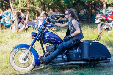 Ukrayna, Kyiv - 9 Temmuz 2011: Sakallı, siyah yelekli ve güneş gözlüklü sert bir adam motosikletine biniyor.