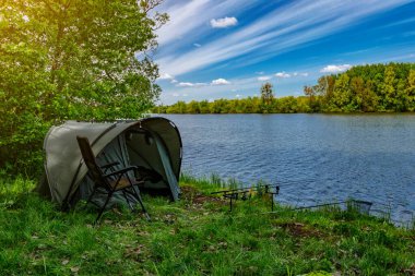 Gölde balık avı. Sazan balıkçılığı manzarası göl manzarası ve bulutlu mavi gökyüzü. Balıkçılık maceraları, sazan balığı avcılığı..