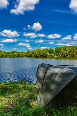 Gölde balık avı. Sazan balıkçılığı manzarası göl manzarası ve bulutlu mavi gökyüzü. Balıkçılık maceraları, sazan balığı avcılığı..
