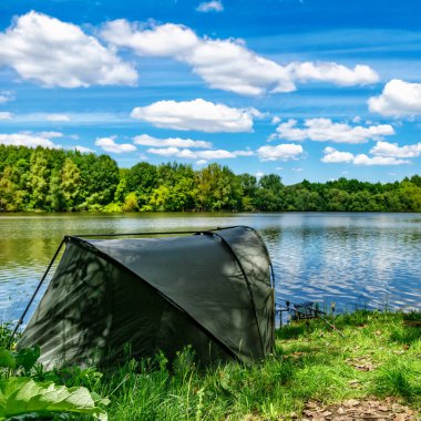 Gölde balık avı. Sazan balıkçılığı manzarası göl manzarası ve bulutlu mavi gökyüzü. Balıkçılık maceraları, sazan balığı avcılığı..