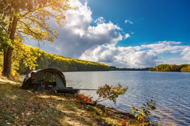 Gölde balık avı. Şafak vakti göle bakan sazan balığı avı manzarası. Balık maceraları, sazan balıkçılığı..
