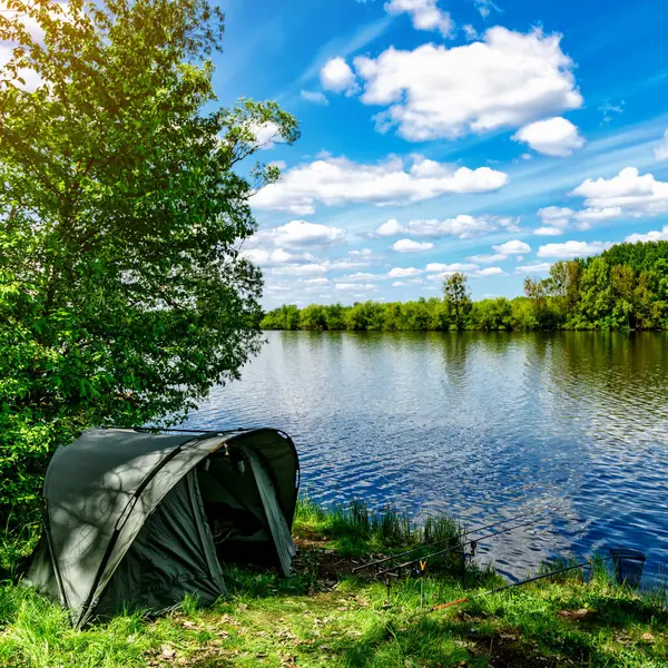 Gölde balık avı. Sazan balıkçılığı manzarası göl manzarası ve bulutlu mavi gökyüzü. Balıkçılık maceraları, sazan balığı avcılığı..