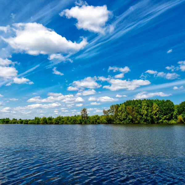 Carpfishing session at the Lake.Carp Angling scenic landscape overlooking lake at and blue sky with clouds.Fishing adventures, carp fishing.