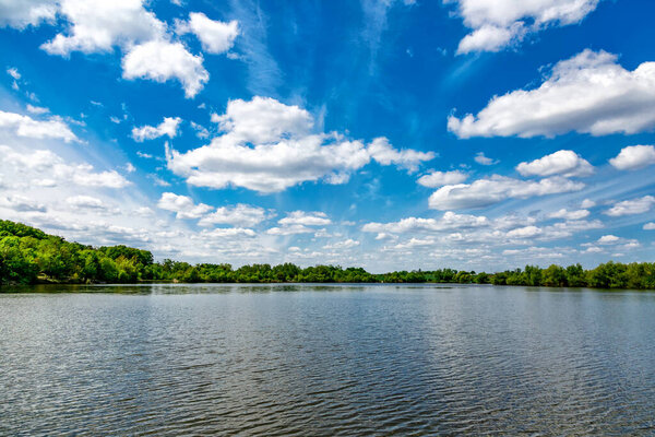 Carpfishing session at the Lake.Carp Angling scenic landscape overlooking lake at and blue sky with clouds.Fishing adventures, carp fishing.