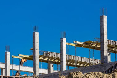 Yeni bir apartman bloğunda çalışma platformları sağlayan kapsamlı yapı iskeleleri, inşaat halindeki uzun binalar, Yeni Bina İnşaat Alanı