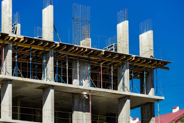 Yeni bir apartman bloğunda çalışma platformları sağlayan kapsamlı yapı iskeleleri, inşaat halindeki uzun binalar, Yeni Bina İnşaat Alanı