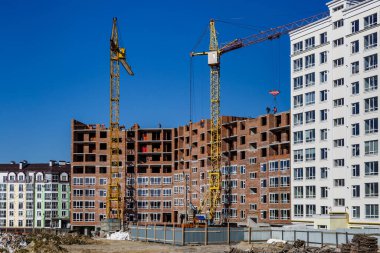 Yeni bir apartman bloğunda çalışma platformları sağlayan kapsamlı yapı iskeleleri, inşaat halindeki uzun binalar, Yeni Bina İnşaat Alanı