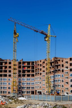 Yeni bir apartman bloğunda çalışma platformları sağlayan kapsamlı yapı iskeleleri, inşaat halindeki uzun binalar, Yeni Bina İnşaat Alanı