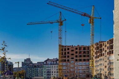 Yeni bir apartman bloğunda çalışma platformları sağlayan kapsamlı yapı iskeleleri, inşaat halindeki uzun binalar, Yeni Bina İnşaat Alanı