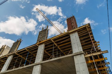 Yeni bir apartman bloğunda çalışma platformları sağlayan kapsamlı yapı iskeleleri, inşaat halindeki uzun binalar, Yeni Bina İnşaat Alanı