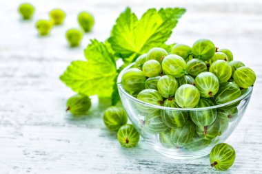 Yeşil Organik Böğürtlenler. Cam bir tabakta olgunlaşmış bektaşi üzümü. Ahşap masada Bektaşi üzümü. Hasat konsepti. Vejetaryen yemeği..