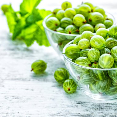 Yeşil Organik Böğürtlenler. Cam bir tabakta olgunlaşmış bektaşi üzümü. Ahşap masada Bektaşi üzümü. Hasat konsepti. Vejetaryen yemeği..