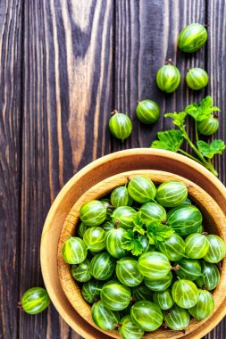 Yeşil Organik Böğürtlenler. Ahşap bir kasede yeşil Bektaşi üzümü. Ahşap masada Bektaşi üzümü. Hasat konsepti. Vejetaryen yemeği..