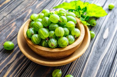 Yeşil Organik Böğürtlenler. Ahşap bir kasede yeşil Bektaşi üzümü. Ahşap masada Bektaşi üzümü. Hasat konsepti. Vejetaryen yemeği..