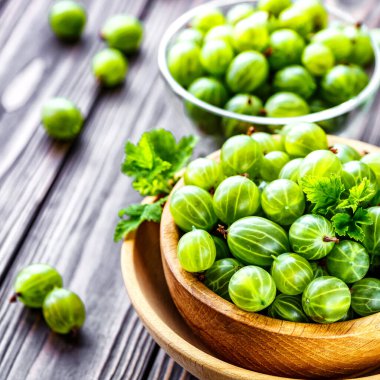 Yeşil Organik Böğürtlenler. Ahşap bir kasede yeşil Bektaşi üzümü. Ahşap masada Bektaşi üzümü. Hasat konsepti. Vejetaryen yemeği..