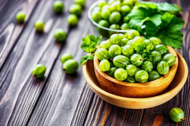 Yeşil Organik Böğürtlenler. Ahşap bir kasede yeşil Bektaşi üzümü. Ahşap masada Bektaşi üzümü. Hasat konsepti. Vejetaryen yemeği..