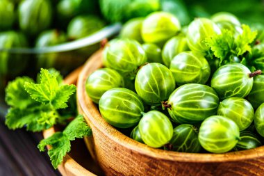 Yeşil Organik Böğürtlenler. Ahşap bir kasede yeşil Bektaşi üzümü. Ahşap masada Bektaşi üzümü. Hasat konsepti. Vejetaryen yemeği..