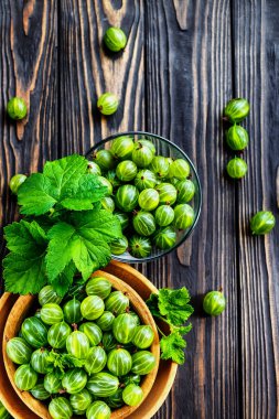 Yeşil Organik Böğürtlenler. Ahşap bir kasede yeşil Bektaşi üzümü. Ahşap masada Bektaşi üzümü. Hasat konsepti. Vejetaryen yemeği..