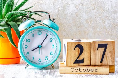 Ahşap takvim ve ahşap zemin üzerinde çalar saat ile planlama ve yönetim konsepti için 27 Ekim tarihli ahşap takvim