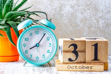Tahta takvimde 31 Ekim tarihli ahşap takvim, ahşap zemin üzerinde çalar saat ile planlama ve yönetim kavramı